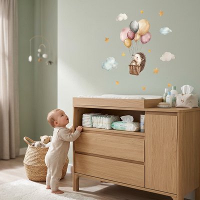 Bébé prenant appui sur une commode dans chambre et admiratif décor magnifique créé par stickers muraux design tendance