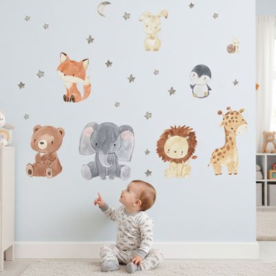 Bébé assis le tapis admirant et pointant doigt mur décoré avec stickers muraux safari