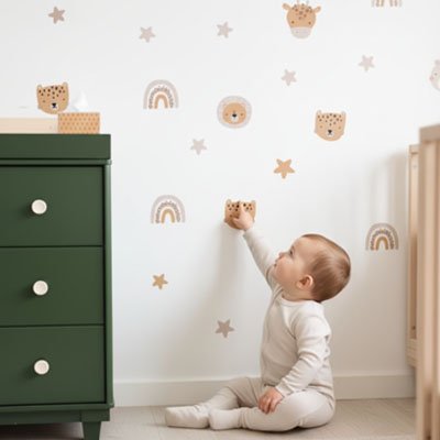 Bébé assis sur le tapis et pointant mur décoré avec stickers muraux enfant savane douce