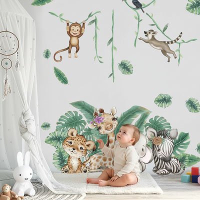 Bébé assis sur le tapis et regardant avec admiration mur décoré avec stickers muraux enfant forêt apaisante