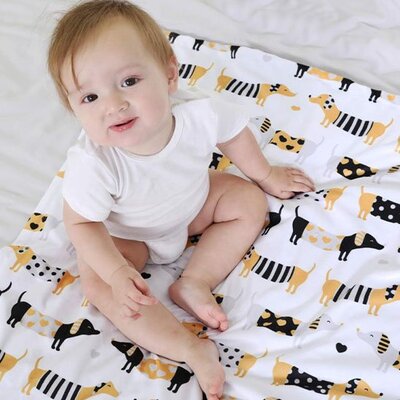 bebe assis vetu de blanc sur couverture bebe doux tresor motifs chiens