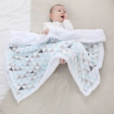 Bébé couché à moitié couvert par Couverture bébé Couette Douceur bleu clair