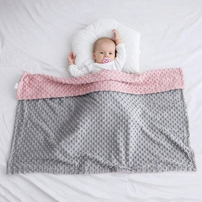 Bébé couché sur dos sur lit avec oreiller blanc couvert par couverture bébé Maxi Epais grise