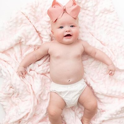 bebe heureux allonge sur dos et sur couverture bebe douceur nature minky rose