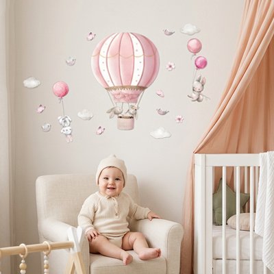 Bébé heureux assis sur le fauteuil dans chambre décorée par stickers muraux chambre décoratifs