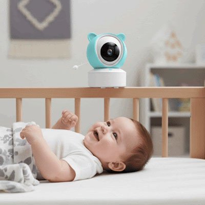 Bébé heureux dans son lit sous surveillance caméra bébé vision complète