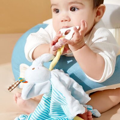 Bébé jouant avec son doudou bébé confort-doux éléphant