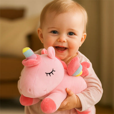 Bébé joyeux et apaisé par peluche licorne Magique rose