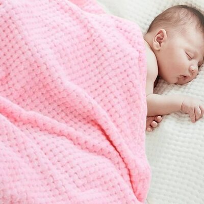 Bébé profondément endormi couvert par Couverture bébé Douce Ecologique rose