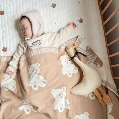 Bébé sereinement endormi dans son lit avec Doudou Coton Bio Ultra-Doux oie à ses côtés