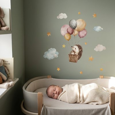 Bébé sereinement endormi sur le berceau dans chambre décorée avec stickers muraux design tendance