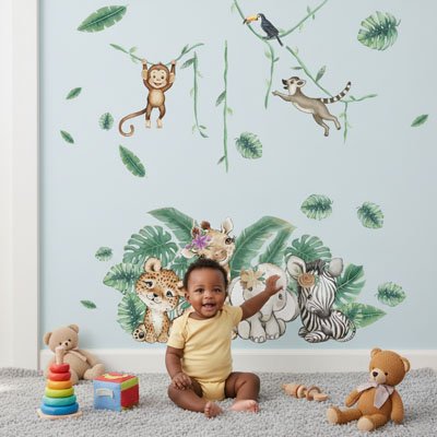 Bébé souriant assis sur le tapis avec jouets et touchant main gauche mur décoré avec stickers muraux enfant forêt apaisante