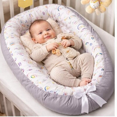 Bébé souriant dans nid d'ange bébé évolutif confort dans lit sa peluche en arrière plan