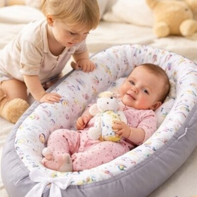 Bébé souriant dans nid d'ange bébé évolutif confort sous regard attentionné grand frère