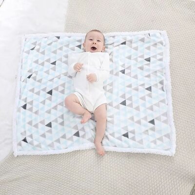 Bébé vêtu de blanc couché sur Couverture bébé Couette Douceur bleu clair