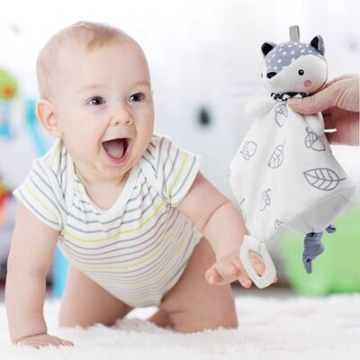 Bébé vêtu blanc rayé jaune bleu et à quatre pattes attiré par Doudou Douceur Plus renard