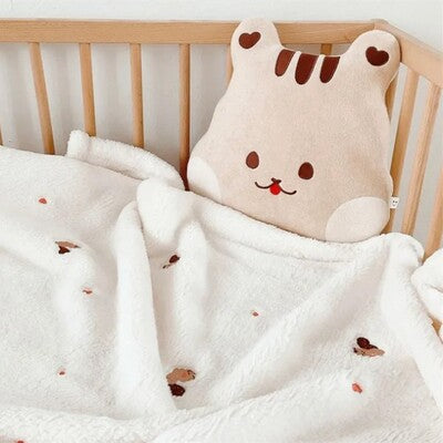 couverture bebe pure douceur minky a picots creme presentee avec un gros lapin en peluche