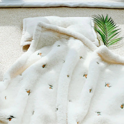 couverture bebe pure douceur minky lisse creme presentee avec un rameau decoratif