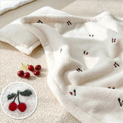 couverture bebe pure douceur polaire creme avec broderie cerises presentee a plat
