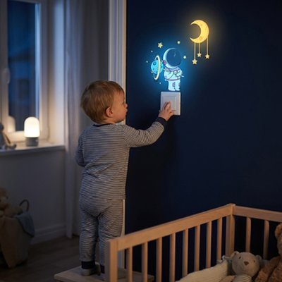Enfant appuyant interrupteur sur le mur orné par stickers muraux chambre déco chic