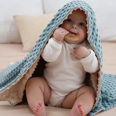 Enfant assis jouet dans bouche recouvert par couverture bébé Maxi Epais bleu