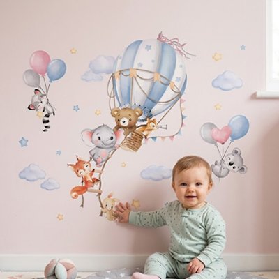 Enfant assis souriant et touchant de la main le mur orné par stickers muraux enfant maxi repositionnables