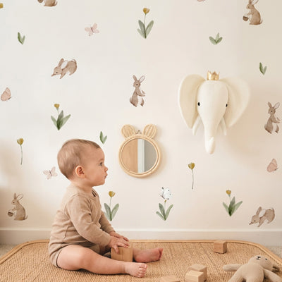 Enfant assis sur la natte jouant et appréciant décoration stickers muraux enfant univers apaisant