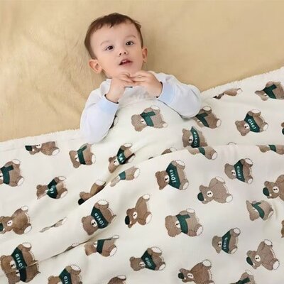 Enfant éveillé et couché sur le dos dans couverture bébé Hiver Chaud ours vert
