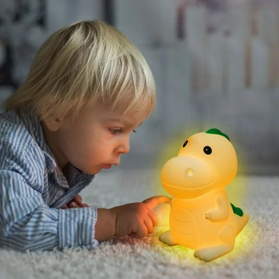 enfant jouant avec veilleuse bebe dinosaurus