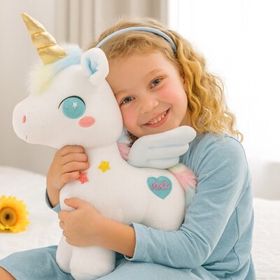 Fillette joyeuse câlinant peluche licorne Enchantée bleu