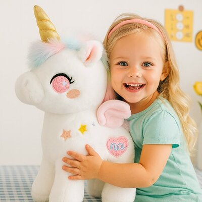 Fillette toute sourire avec peluche licorne enchantée rose