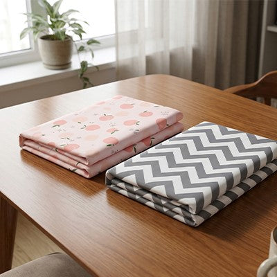 Gros plan des variantes pêche et  strié bleu du drap housse lit bébé tout doux exposés sur une table