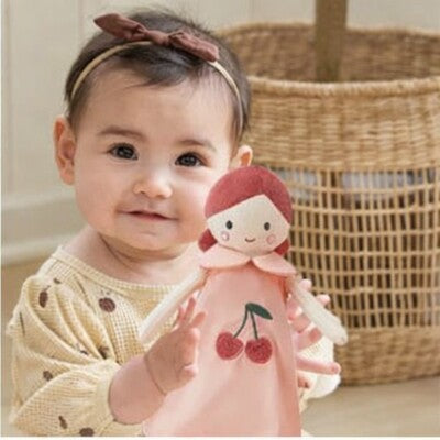 Gros plan fillette assise tenant dans ses bras Doudou Ultra-Doux poupée douceur cerise