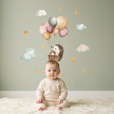 Gros plan sur bébé assis sur le tapis-gris dans chambre décorée par stickers muraux design tendance