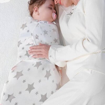 Maman aux côtés bébé endormi emmailloté dans couverture emmaillotage dodoserein étoile