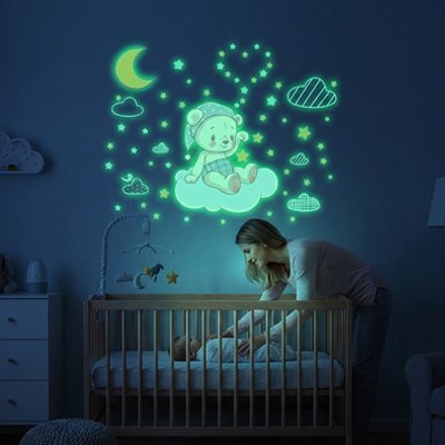 Maman couchant bébé dans la chambre décorée par stickers muraux chambre nuit magique
