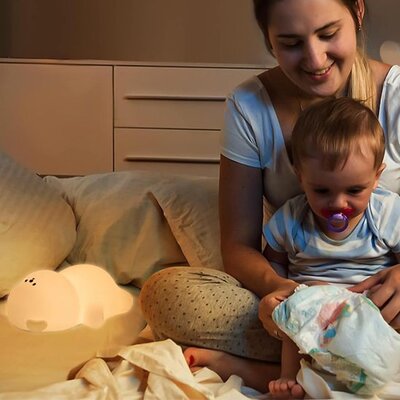 Maman et fille partageant moment complicité sous éclairage doux bébé veilleuse ours lumière