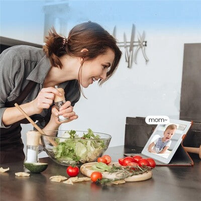 Maman faisant cuisine et surveillant bébé en pleurs à travers moniteur caméra bébé sans wifi vision HD Plus