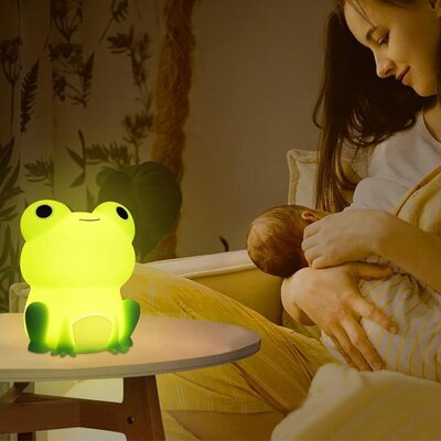 Mère berçant bébé sous lumière douce et apaisante veilleuse bébé grenouille