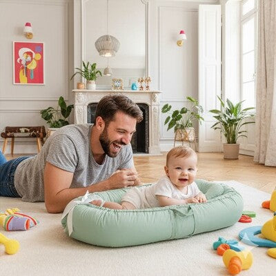 Papa heureux jouant avec bébé dans nid d'ange bébé coton évolutif et entouré jouets