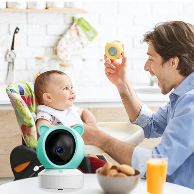 Papa jouant avec bébé sous surveillance bienveillante caméra bébé vision HD posée sur table
