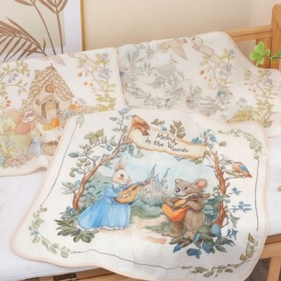 Trois couvertures bébé Douceur Sécurisante motifs oies, écureuils et lapins étalées côte à côte sur matelas lit bébé blanc