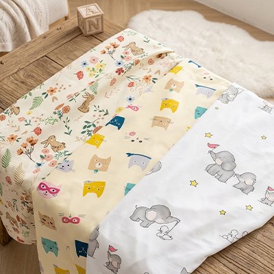 Trois variantes drap housse lit bébé douceur et confort exposées sur une table