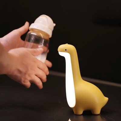 bebe jouant avec la veilleuse bebe dinosaura