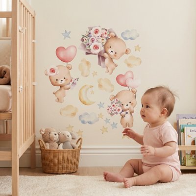 Vue profil bébé assis sur le tapis dans chambre décorée par stickers muraux enfant univers douillet