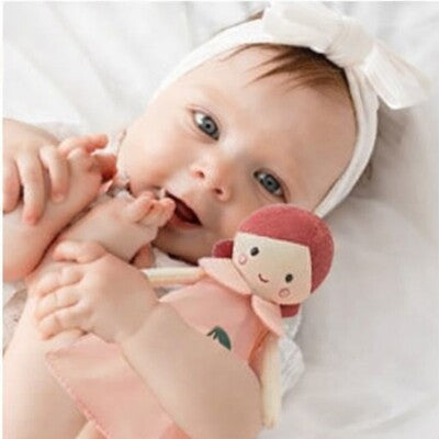 Vue profil bébé couché sur dos tenant dans ses bras Doudou Ultra-Doux poupée douceur cerise