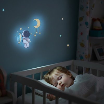 Vue profil droit de bébé profondément endormi dans chambre décorée par stickers muraux chambre déco chic