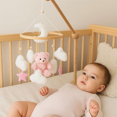 Vue profil gauche de bébé vêtu de rose clair couché dans son lit et attiré par mobile bébé musical relaxant
